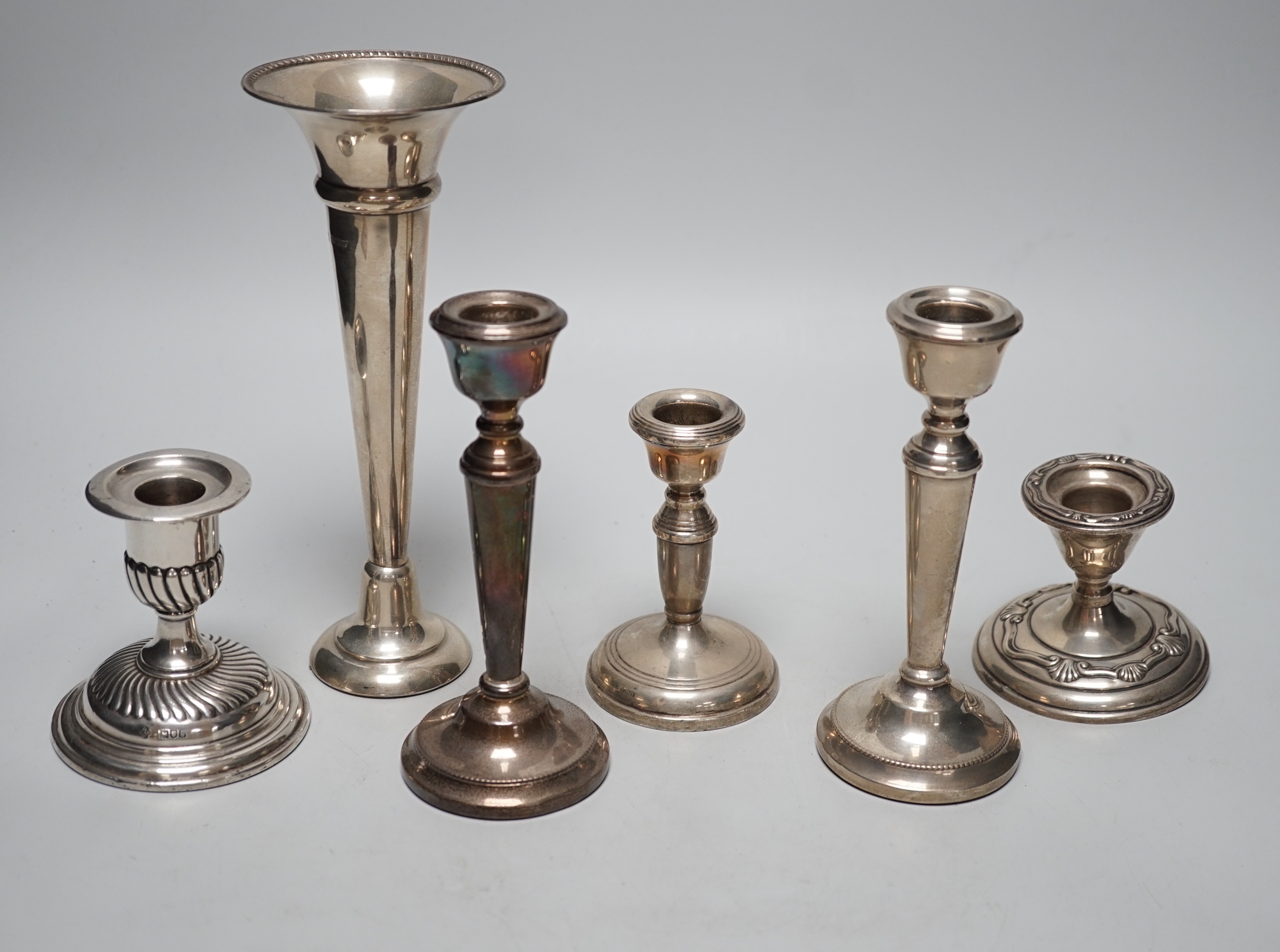 A pair of modern silver mounted candlesticks, 15.4cm, weighted, three other silver mounted dwarf candlesticks and a silver mounted spill vase.